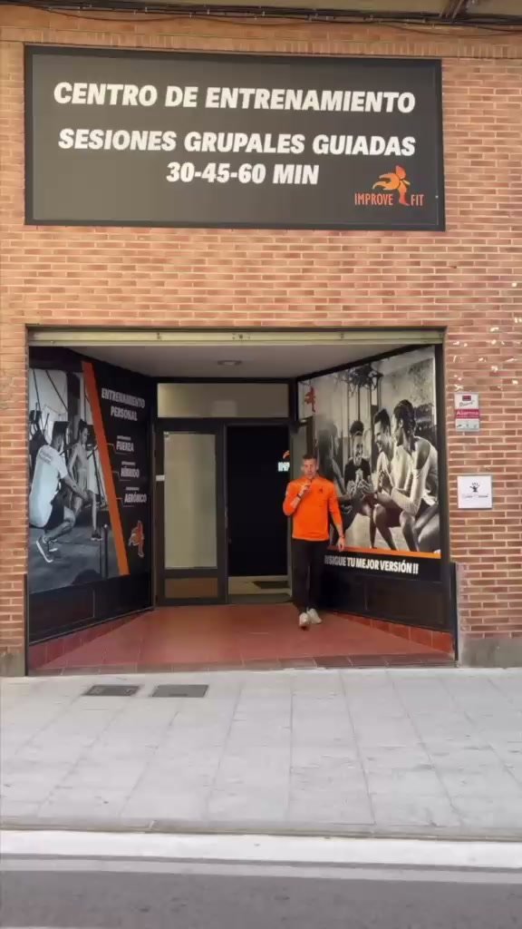 Fachada de ladrillo del centro ImproveFit, con el cartel «Centro de entrenamiento, sesiones grupales guiadas» sobre la puerta.
